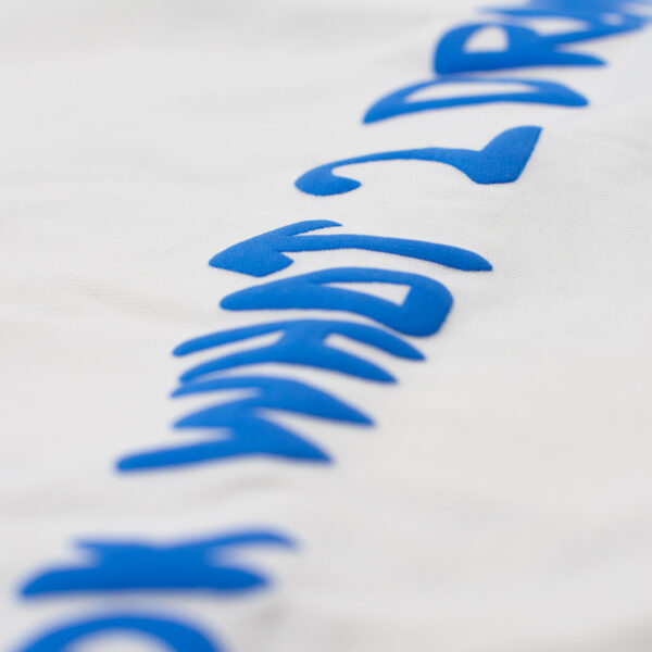 Texto en relieve azul sobre tela blanca con la frase 'LOOK WHAT 2 DRAW' en tipografía irregular.