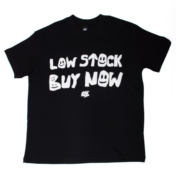 Camiseta negra con la frase 'LOW STOCK BUY NOW' en blanco y tipografía con caritas sonrientes.
