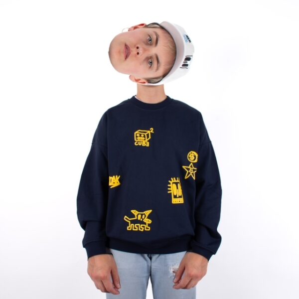 Una persona con sudadera azul y bordados amarillos, con la cabeza flotando separada arriba.