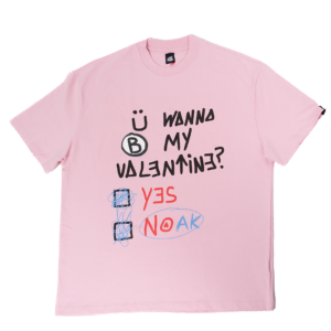 Camiseta rosa con la frase 'Ü WANNA B MY VALENTINE?' y opciones 'YES' o 'NOAK' en diseño manuscrito.